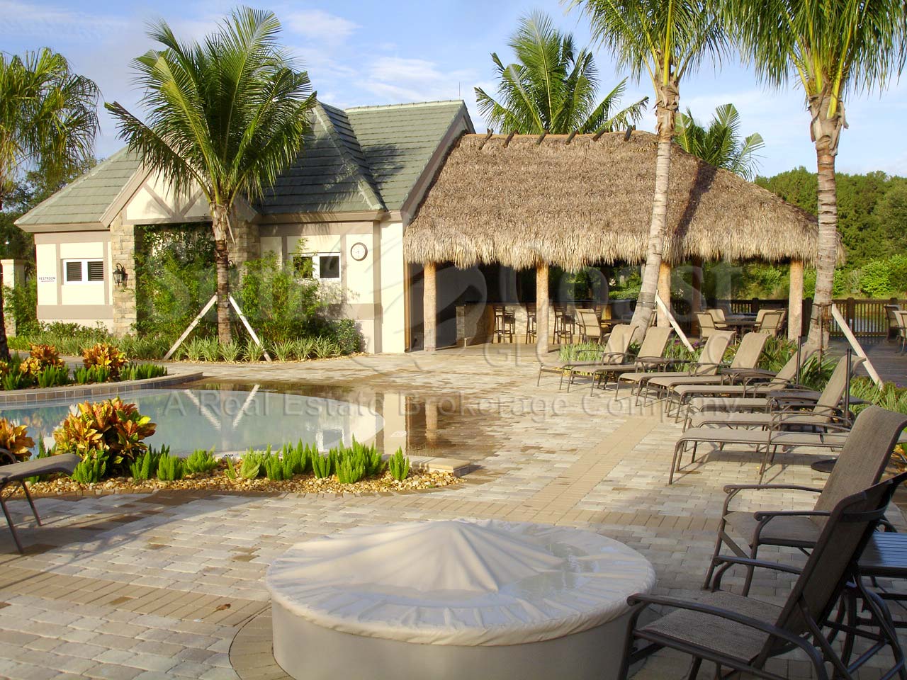TWIN EAGLES Golf and Country Club pool area with fire pit and tiki hut